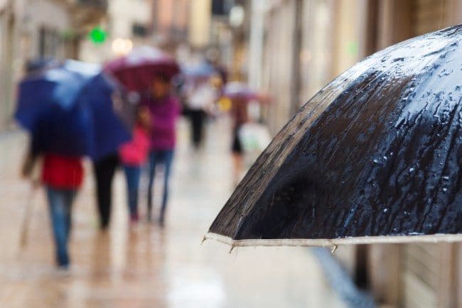 Walkers in rain with umbrella